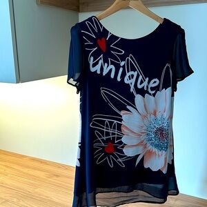 This stylish navy blue top features a floral pattern with a large daisy